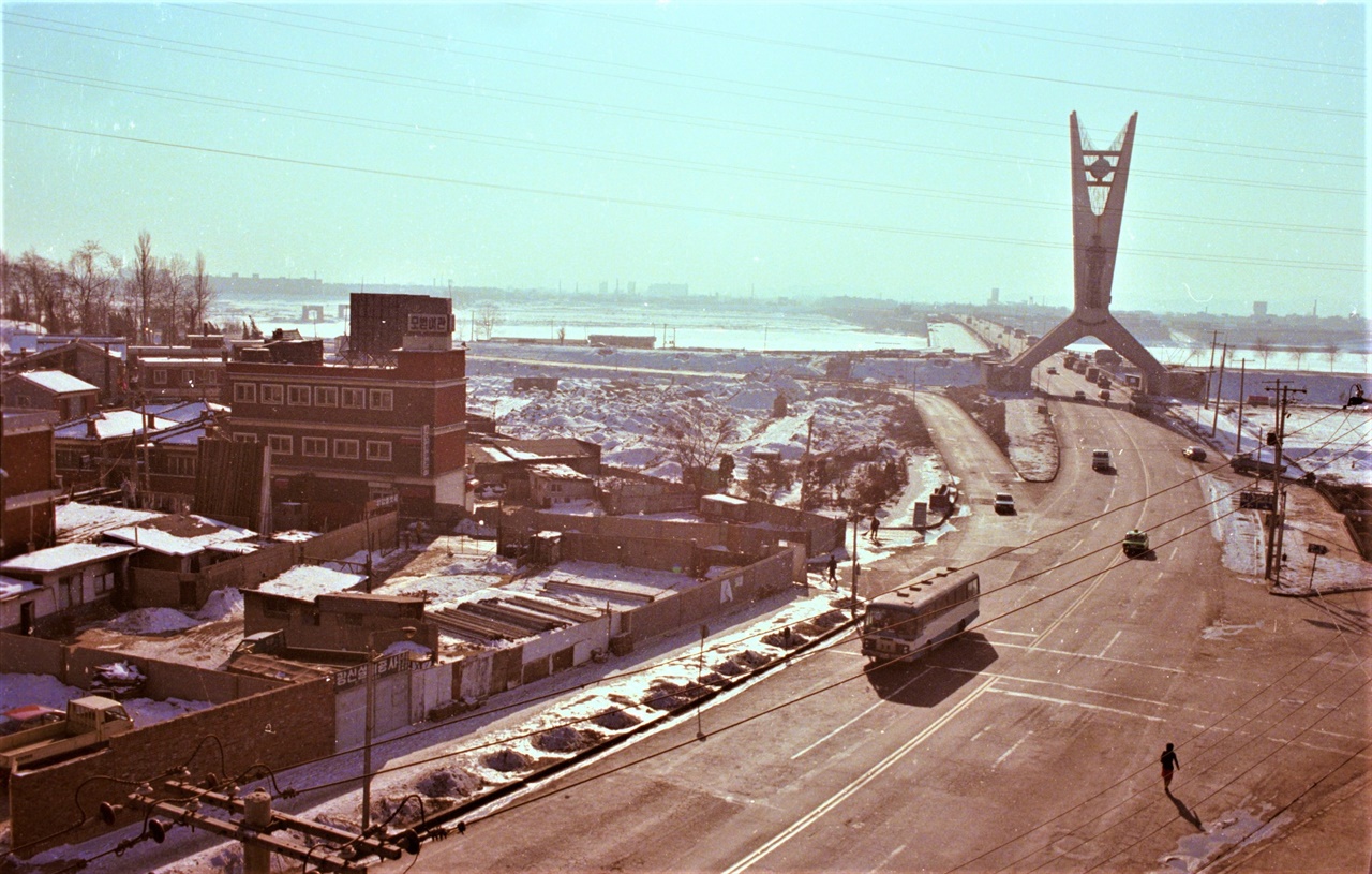 지금의 합정역 부근에서 남쪽으로 바라 본 1981년 양화대교 모습이다. 여전히 '유엔 탑'은 높기만 하고, 한강 제방이 뚜렷하다. 아직 도시고속도로도 없었고, 지금에 비하면 도로는 한산하기 까지 하다. 양화대교 좌측으로 새로 다리를 공사하는 모습이 흐릿하게 보인다.