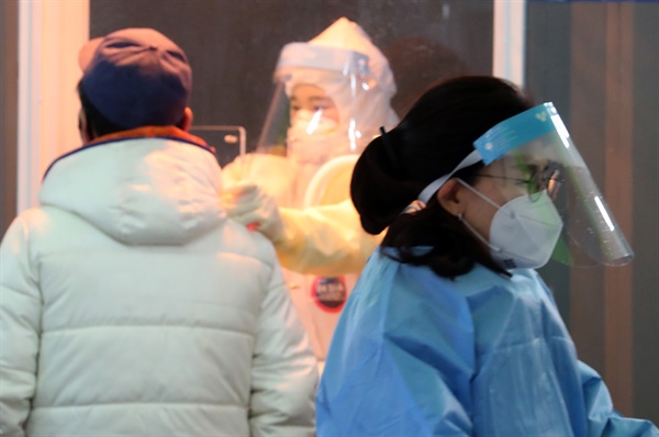 26일 오전 서울역광장에 설치된 임시선별진료소에서 의료진이 검체를 채취하고 있다.