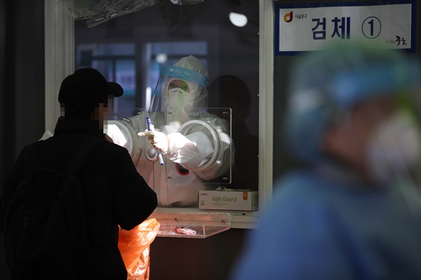 1월 29일 오후 서울역광장에 설치된 임시선별진료소에서 의료진이 검체채취를 하고 있다.