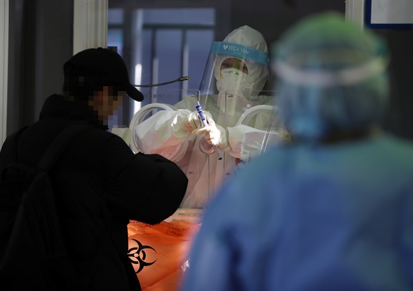 1월 29일 오후 서울역광장에 설치된 임시선별진료소에서 의료진이 검체채취를 하고 있다.