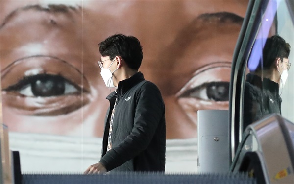 영국발 변이 바이러스의 첫 지역사회 집단감염 사례가 발생한 가운데 4일 오전 인천국제공항 제1터미널에서 마스크를 쓴 인물 그라피티 앞으로 한 시민이 지나고 있다.