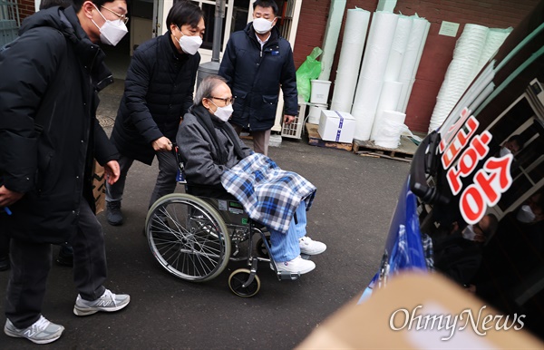 지난 10일 이명박씨가 기저질환 치료를 위해 동부구치소를 나와 머물던 서울대병원에서 퇴원하기 위해 휠체어를 타고 법무부 호송차로 향하고 있다.