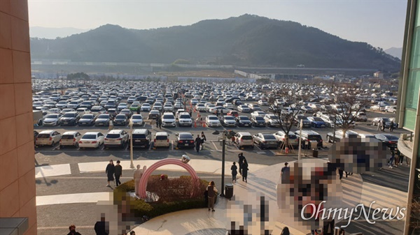 13일 오후 경남 김해장유에 있는 롯데프리미엄아울렛 주차장에 차량이 가득 차 있다. 사람들이 가게로 들어가기 위해 줄을 서 있다.