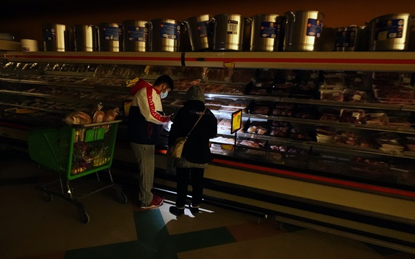 댈러스에 위치한 식료품 점에서 고객들이 휴대폰 불빛을 이용하여 식품을 확인하고 있다. 