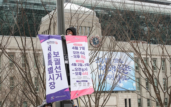 지난 16일 서울 중구 서울시청 앞 광장에서 서울시 선거관리위원회 관계자들이 선거를 홍보하는 현수막을 게시하고 있는 모습. 