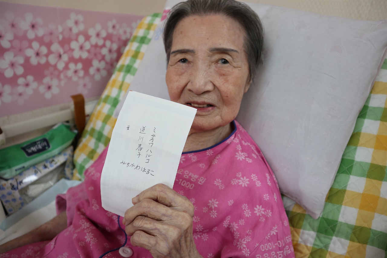 할머니가 자신이 쓴 일본 이름을 들고 있다. 