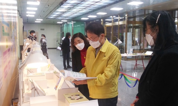 조희연 서울시교육감이 마을 주민들과 자치구, 교육지원청이 함께 만든 25개 자치구 마을교과서를 유심히 살펴보고 있다. 