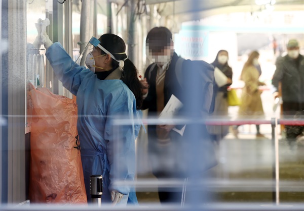 2월 27일 오전 서울역에 설치된 임시선별진료소에서 관계자가 검체 채취 장소를 정리하고 있다.