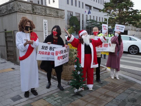 산타와 예수 복장을 한 활동가들이 메시지를 전하고 있다
