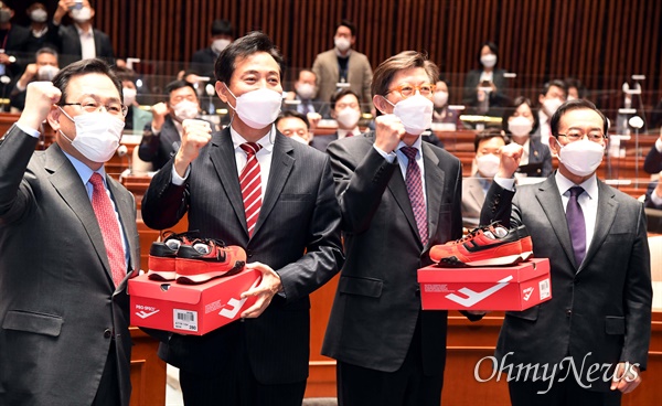  국민의힘 오세훈 서울시장 후보와 박형준 부산시장 후보가 5일 오전 국회에서 열린 의원총회에 참석해 주호영 원내대표와 이종배 정책위의장으로부터 빨간 운동화를 받고 파이팅을 외치고 있다.