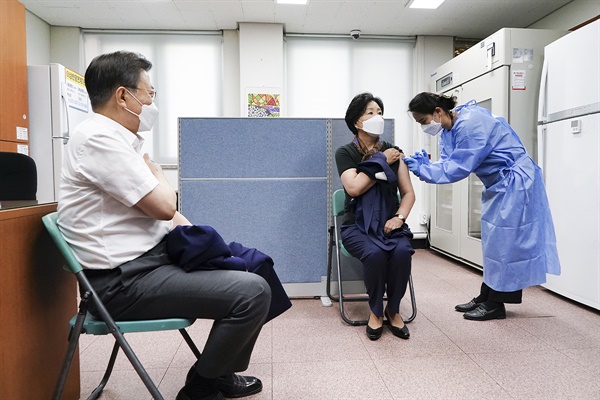 문재인 대통령이 23일 오전 서울 종로구보건소에서 아스트라제네카(AZ)사의 코로나19 백신을 접종을 받은 후 김정숙 여사의 백신 접종을 지켜보고 있다.