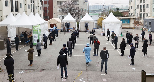 지난 3월 21일 오전 서울 금천구청 앞에 마련된 외국인 임시선별검사소에서 외국인들이 검체 검사를 받기 위해 줄을 서 있다. 