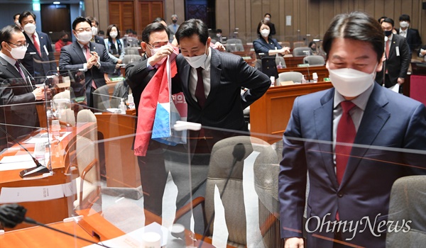  국민의힘 오세훈 서울시장 후보가 24일 서울 여의도 국회에서 열린 의원총회에서 주호영 원내대표에게서 숫자 2번이 적힌 당복을 입고 있다. 오른쪽은 국민의힘 서울시장 후보에게 힘을 보태기로 한 안철수 공동선대위원장.
