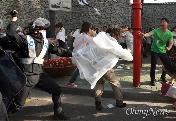 1일 오전 7시 45분경 서울 안국동 네거리에서 강제해산작전에 나선 경찰이 도망치는 한 시민의 머리를 몽둥이로 내려치려고 하고 있다.