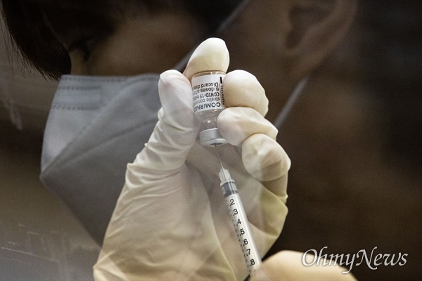 지난해 4월 서울 성동구 코로나19 예방접종센터에서 파견 나온 서울대병원 간호사가 화이자 백신을 주사기로 옮기는 모습.