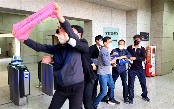김동성 금속노조 부위원장을 비롯한 조합원들이 불법파견 소송 판결 지언에 항의하며 20일 대법원 1층 현관에 들어가 손펼침막을 펼쳐보였다.