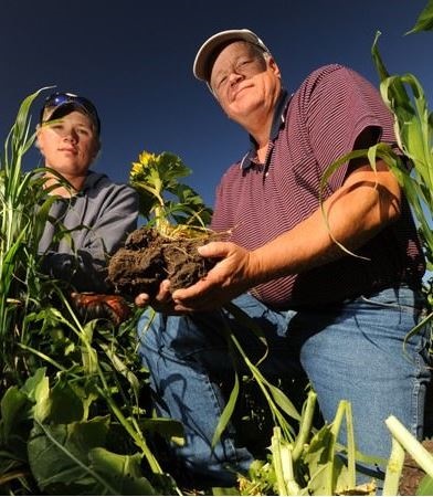 건강한 토양을 움켜쥔 게이브 브라운(오른쪽)과 그의 아들 폴 브라운.