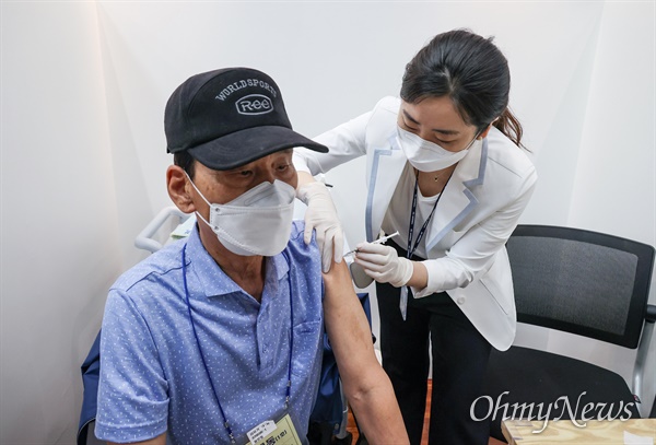 어르신이 지난 22일 오후 서울 용산구 용산아트홀에 마련된 백신접종센터에서 신종 코로나바이러스 감염증(코로나19) 화이자 백신을 접종 받고 있다.