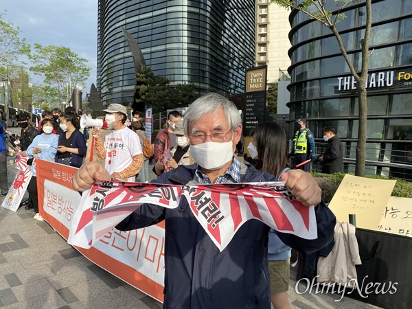 24일 오후 서울 종로구 일본대사관에서 열린 '일본 방사능 오염수 방류저지 1만 국민행동'에 시민들이 기자회견을 열어 일본 정부의 후쿠시마 오염수 방류 결정을 규탄하고 있다. 한 시민이 전범기를 찢고 있다.