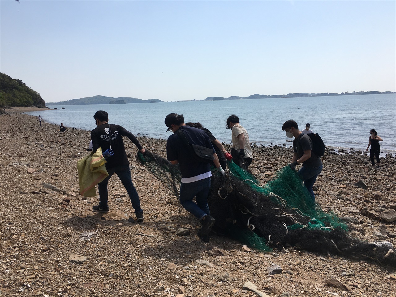  폐그물을 옮기는 자원봉사자들의 모습. 플라스틱 폐그물은 썩어 없어지지도 않고 성인 남성 여러 명이 붙어 옮겨야 할만큼 무겁다. 