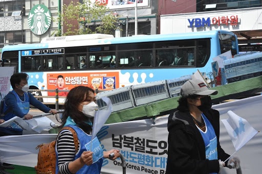 남북철도잇기 행진단이 지나가자 버스 안의 시민들이 행진단을 보고 있다