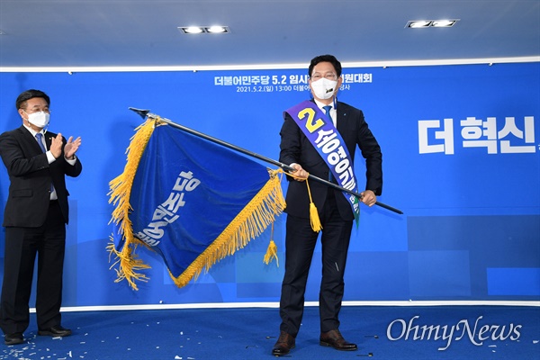 더불어민주당 새 대표로 선출된 송영길 의원이 2일 서울 여의도 중앙당사에서 열린 임시전국대의원대회에서 당기를 흔들어 보이고 있다.