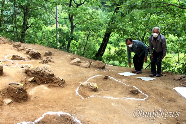  진주시 명석면 화령골에 있는 한국전쟁전후 민간인 학살지에서 나온 유해, 유품. 진주유족회 회원들이 큰절하고 있다.