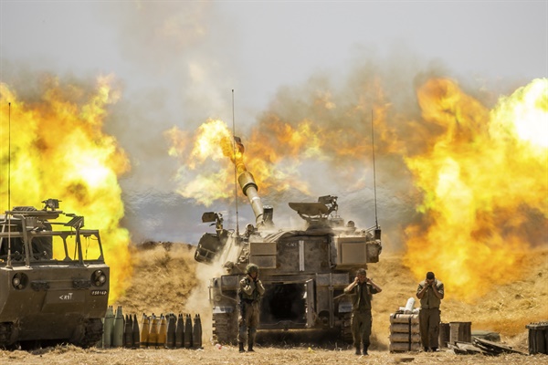 지난 12일(현지시간) 이스라엘과 팔레스타인 자치 지역인 가자지구 경계에서 이스라엘군 야포가 포탄을 쏘고 있다. 이스라엘군은 가자지구 무장 정파 하마스와 화력전을 벌여 사상자가 급증했다. 2021.5.12