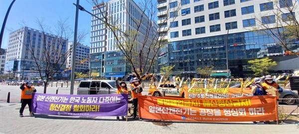 일본 산켄전기 서울영업소가 있는 서울 마곡동 건와빌딩 앞에서 현수막을 들고 집회를 하고 있는 한국산연 해고노동자들]