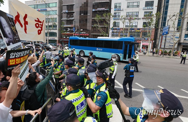 법원앞에 모인 시민들이 정인이 양모가 탄 것으로 보이는 호송차를 향해 강력한 처벌을 촉구하며 사진과 피켓을 들고 있다.