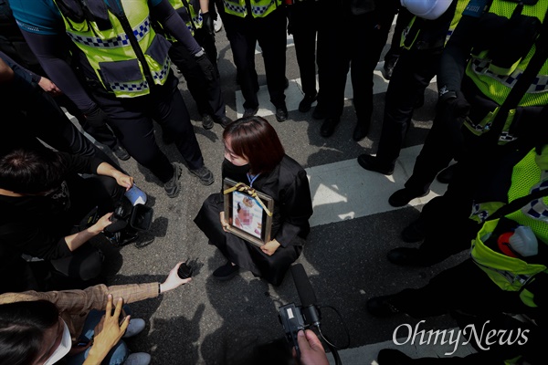 2021년 5월 14일 오후 16개월된 입양아 정인이를 학대해 숨지게 한 양부모에 대한 1심 선고가 열린 서울남부지법앞에서 한 시민이 정인이 사진을 들고 주저앉아 강력한 처벌을 촉구하고 있다.
