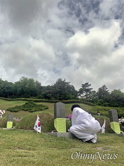 18일 광주 북구 국립5.18민주묘지에서 열린 5.18민주화운동 41주년 기념식 후 고 장재철의 어머니 김점례씨가 아들의 묘 앞에서 사진을 어루만지고 있다. 