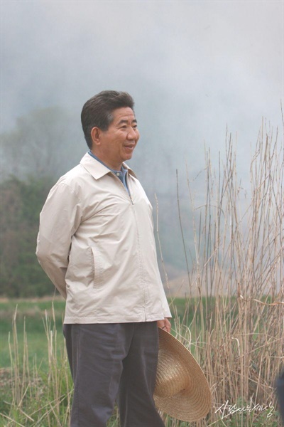 밀짚모자와 작업복 차림으로 봉하마을을 둘러보는 노무현 전 대통령.