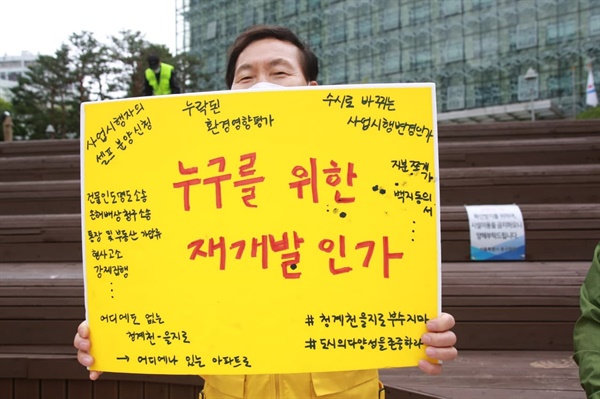 기자회견에 참여한 세운3구역 상인이 재개발의 문제점들이 적힌 피켓을 들고 있다.