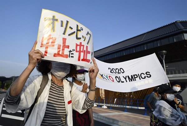 25일 일본 교토현 가메오카시 상가운동장 앞에서 열린 도쿄올림픽 반대 시위. 이날 이 경기장 안에서 올림픽 성화봉송이 진행됐다. 한 참가자가 "올림픽 중지다 중지"라고 적힌 팻말을 들고 있다. 