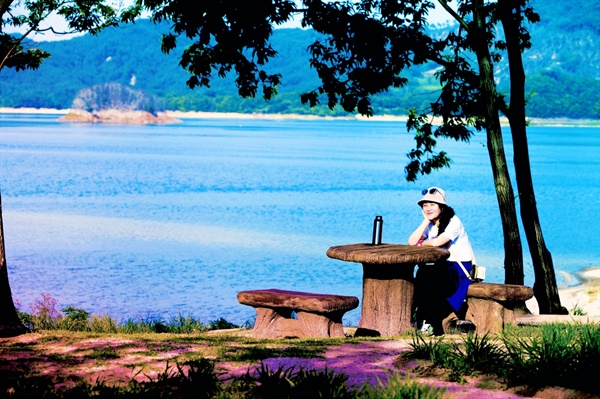 '명상의 정원'에 놓여 있는 테이블 벤치에서. 호수에 관동묘려 앞쪽에 있는 가마우찌들의 집단 서식지인 모자섬이 보인다. 사진 속 인물은 서승희 서산 해미읍성 상설공연 총예술감독.