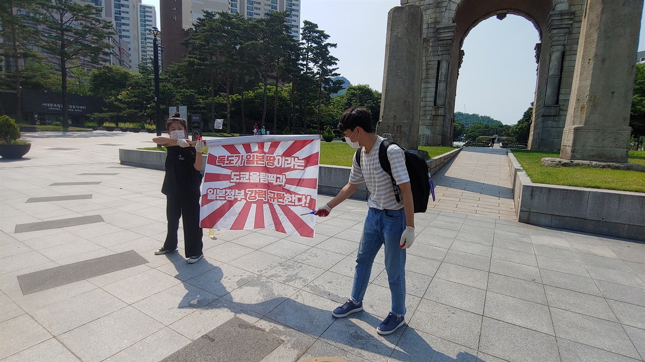  독립문 앞에서 전범기에 불을 붙이려 하고 있다.