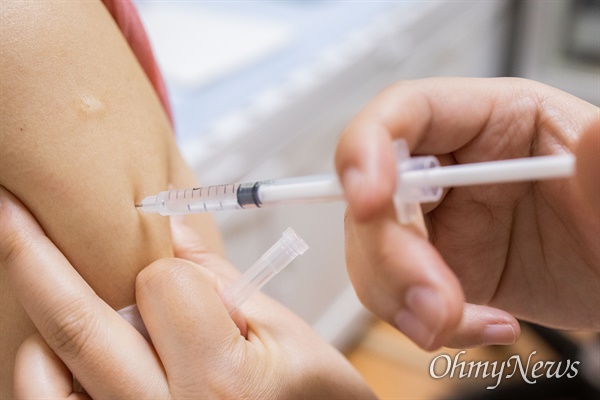 8일 오전 경기도 구리시 보건소에서 2차 접종을 마친 시민을 대상으로 '백신접종' 스티커를 신분증에 부착해 주고 있다.