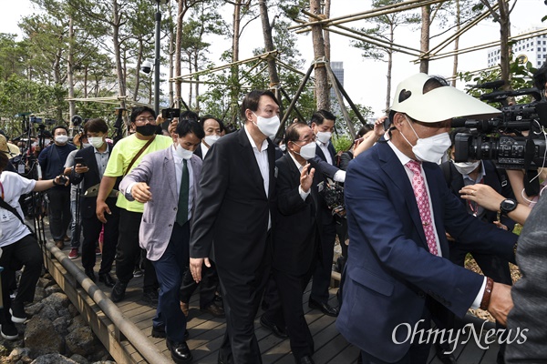 지난 6월 9일 윤석열 전 검찰총장이 서울 중구 남산예장공원 개장식 겸 이회영기념관 개장식에 참석해 이동하는 모습이다. 윤 전 총장 바로 뒤에서 그를 보호하는 듯한 자세를 취하며 걸어가고 있는 회색 재킷 차림의 인물이 항문에 침을 놓아 기를 불어넣어준다는 항문침 전문가 이병환씨다.