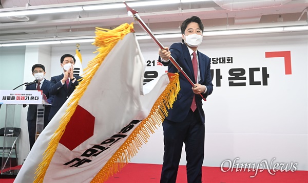 국민의힘 이준석 신임 당 대표가 11일 서울 여의도 중앙당사에서 열린 전당대회에서 당기를 흔들고 있다.
