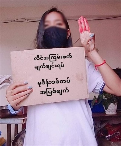 미얀마 시민이 "강간한 군대 중대"라고 쓴 손팻말을 들고 있다.