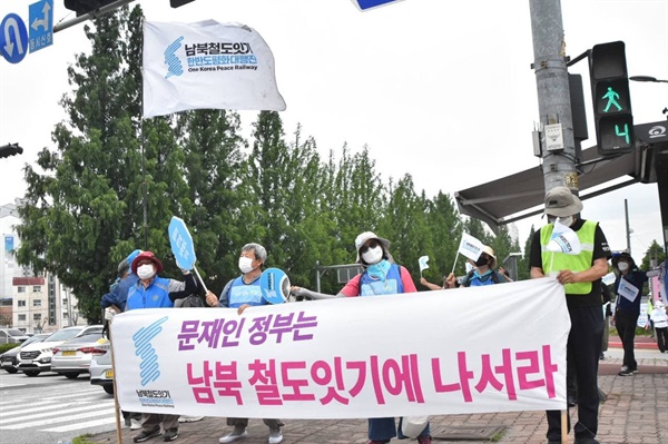 행진 참가자들이 충무로사거리에서 "문재인 정부는 남북철도잇기에 나서라" 현수막을 펼치고 캠페인을 진행하고 있다.