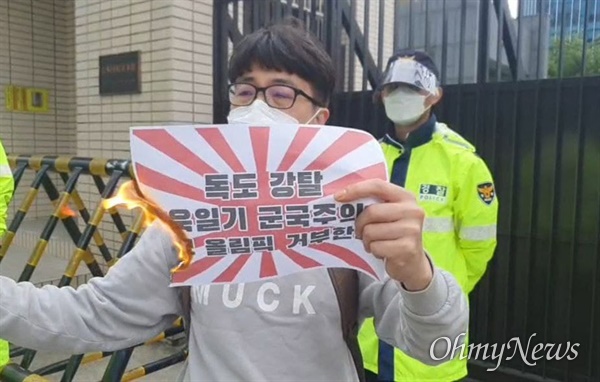 16일 부산 동구 일본영사관에서 "일본의 독도 강탈 야욕을 규탄한다"며 한국대학생진보연합(대진연) 소속 학생이 A4 크기의 용지에 인쇄된 전범기를 라이터로 태우고 있다.