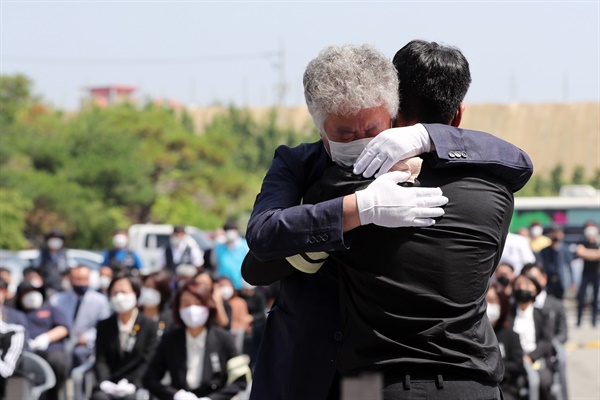  평택항에서 일하다 사고로 숨진 20대 청년 노동자 고(故) 이선호 씨의 아버지 이재훈 씨가 19일 오전 경기 평택시 안중백병원 장례식장에서 열린 이씨의 시민장(葬)에서 추모사를 마친 이씨의 친구를 안아주고 있다. 2021.6.19