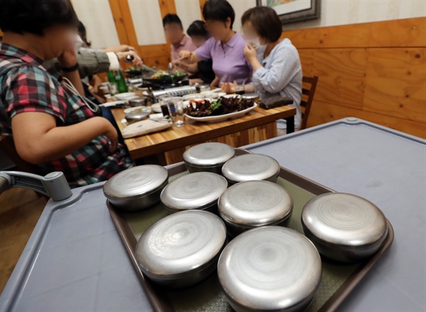 광주에서 사적 모임이 8명까지 가능해진 18일 오후 광주 북구청 인근 식당에서 종업원이 한 테이블에 모인 8명 손님에게 공깃밥을 가져다 주고 있다.
