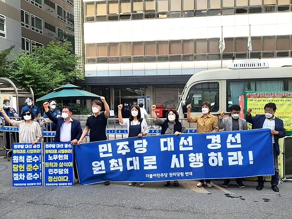 더불어민주당 권리당원 연대가 서울 여의도 민주당사 앞에서 '경선 연기 반대' 구호를 외치고 있다.