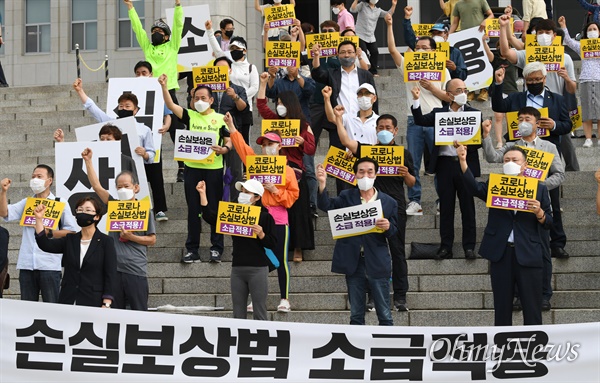  28일 오전 서울 여의도 국회 본청 앞 계단에서 열린 코로나 손실보상법 소급적용 촉구 결의대회에서 참가자들이 구호를 외치고 있다.