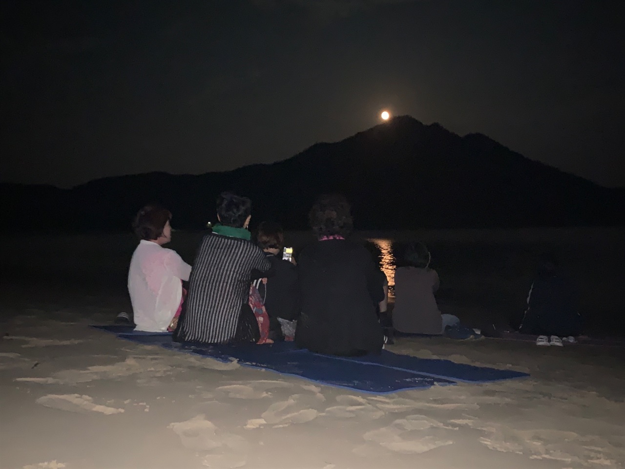 섬마을인생학교 참여자들이 시목 해변에서 떠오르는 달을 향해 바라보고 있다.