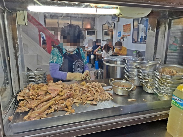 입구 창 너머에서는 아주머니 한 분이 닭고기를 손질하고 있다. 