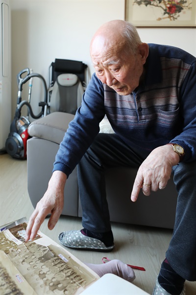 김정일 옹이 아버지의 사진을 보며 설명하고 있다.